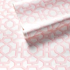 a pink and white wallpaper with geometric designs on it's surface, including a roll of toilet paper