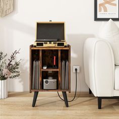 a white couch sitting next to a table with an old record player on top of it