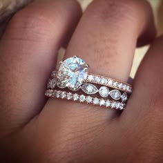 a woman's hand with two wedding rings on top of her finger and the ring is