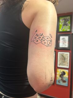 a woman with a tattoo on her arm that has two dices in the middle