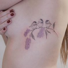 a woman's breast with two birds on it and flowers around the breast area