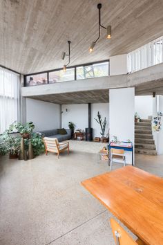 an open living area with wooden furniture and plants