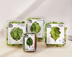 four packaged lettuce sitting on top of a table