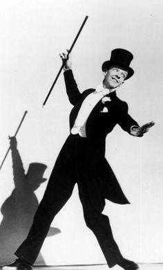 a man in top hat and tails holding two canes