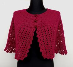 a red crocheted cardigan on a mannequin