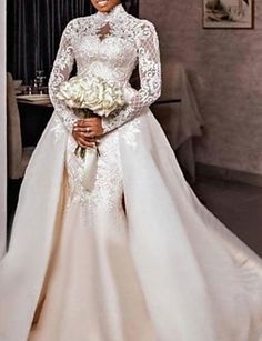 a woman in a wedding dress standing next to a table