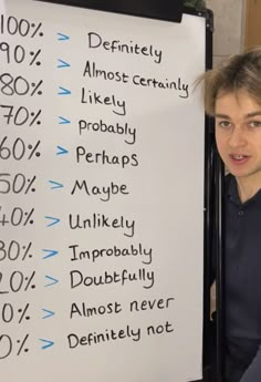 a young man standing next to a white board with numbers on it that say percentage