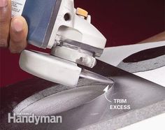 a person using a pair of scissors to trim a piece of metal