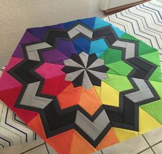 a multicolored quilt is laying on the floor