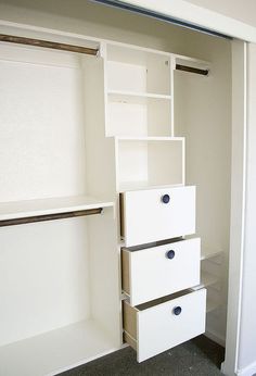 an empty closet with white drawers and shelves