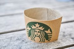 a starbucks cup sitting on top of a wooden table