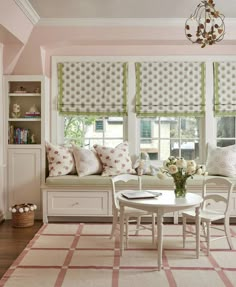 a living room with white furniture and pink walls