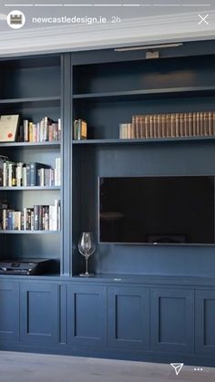 a living room with blue bookcases and a flat screen tv on the wall