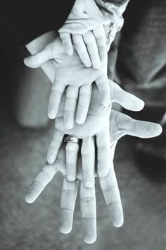 black and white photograph of multiple hands holding each other