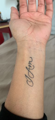 a person's hand with a tattoo on it that says love in cursive writing