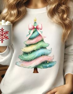 a woman wearing a christmas tree sweater holding a mug