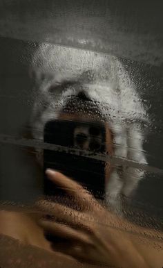 a person taking a selfie in front of a mirror with water splashing on it