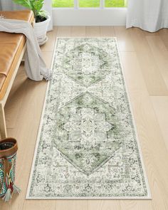 a green and white area rug with an ornate design on the floor in front of a window