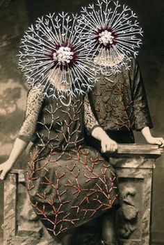 an old photo of two women sitting on a chair with their faces covered in intricate designs