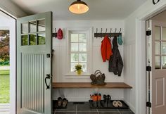 an entryway with shoes and umbrellas hanging on hooks