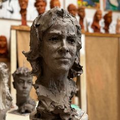 a clay sculpture of a woman's head on a table