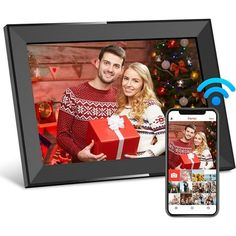 an image of a man and woman in front of a christmas tree with a phone