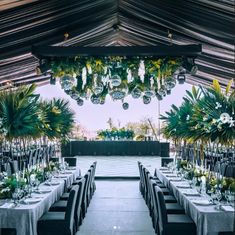 an outdoor dining area with tables, chairs and chandelier hanging from the ceiling