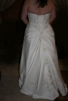 a woman in a white wedding dress is standing