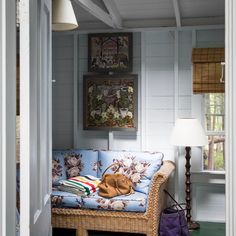 a wicker couch in the corner of a room with white walls and green flooring