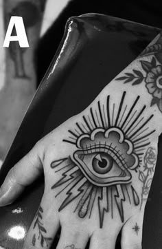 a hand with an all seeing eye tattoo on it