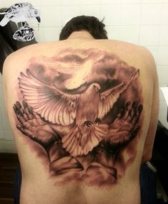 the back of a man's shoulder with two hands and a dove on it