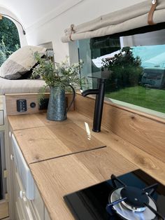 a stove top oven sitting in the middle of a kitchen next to a counter with a potted plant on it