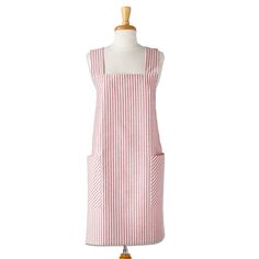 a pink and white striped apron on a mannequin stand with a wooden dummy