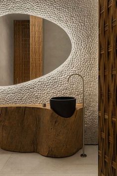 a bathroom with a wooden sink and round mirror