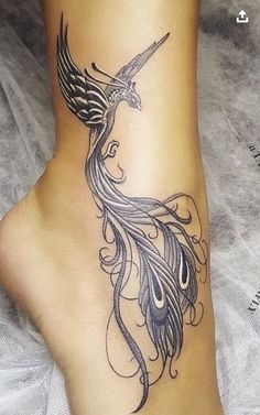 a woman's foot with a bird tattoo on it