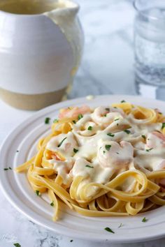 shrimp alfredo pasta with homemade alfredo sauce on a white plate