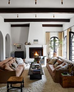 a living room filled with furniture and a fire place in the middle of a room