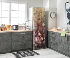 a kitchen with grey cabinets and flowers painted on the side by side refrigerator freezer