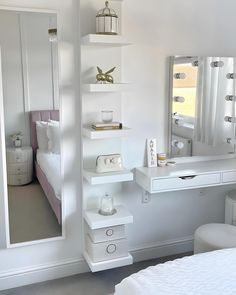 a white bedroom with a bed, desk and mirror