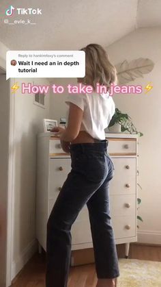 a woman standing in front of a dresser with her back turned to the camera and texting, how to take in jeans?