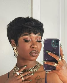 a woman taking a selfie with her cell phone and wearing gold jewelry on her neck