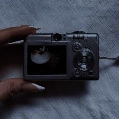 a woman's hand holding a camera with food on it