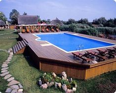 an above ground swimming pool surrounded by lawn chairs