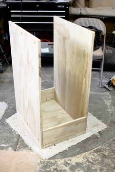 a wooden box sitting on top of a floor next to a pile of construction materials