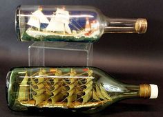 a ship in a bottle that is sitting on the ground next to another model boat