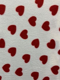 red hearts are arranged on white fabric