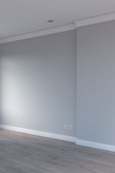 an empty room with white walls and wood floors is shown in the foreground, there are no people or objects on the floor