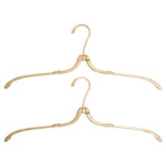 three gold metal clothes hangers on a white background