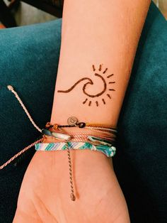 a woman's arm with a tattoo on it and a bracelet around her wrist