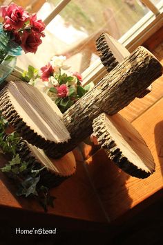 a vase filled with flowers sitting on top of a wooden table next to a window